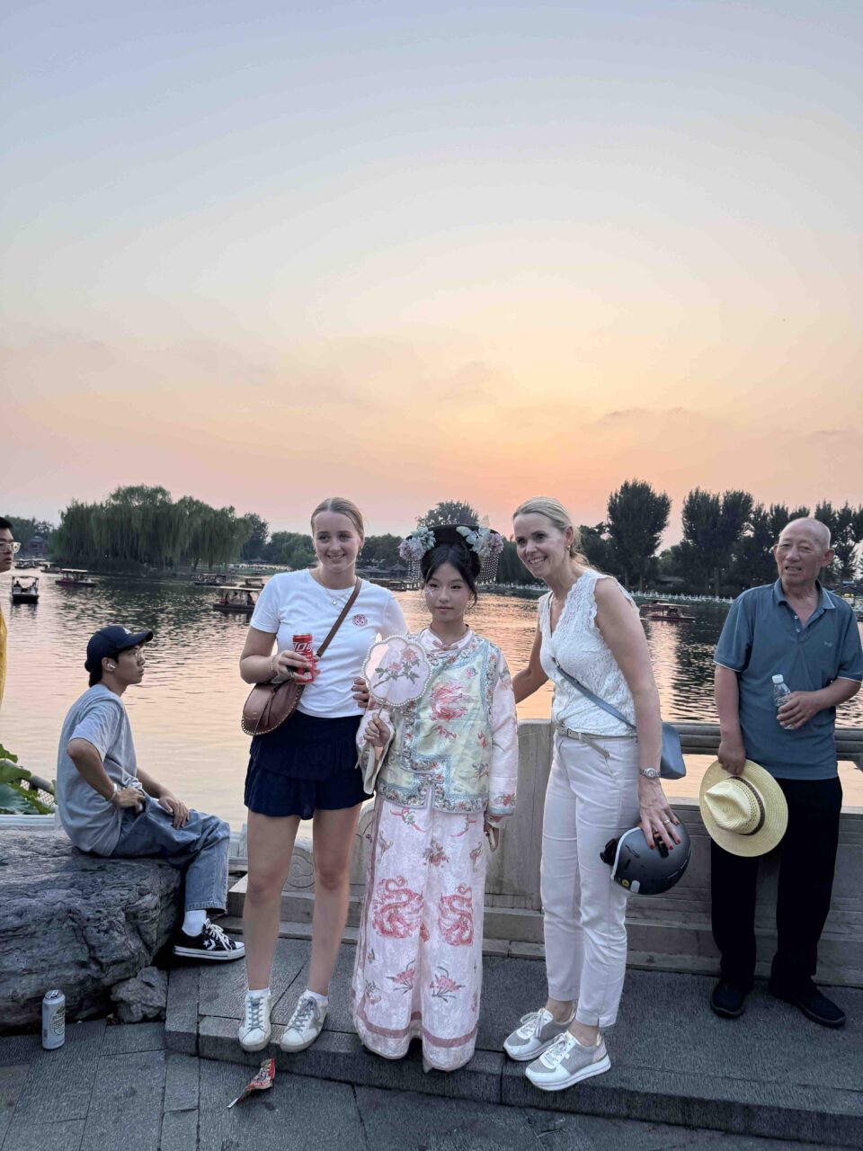 Guests and locals smiling together for a group photo in a Beijing hutong — the warm community of local time in Beijing.