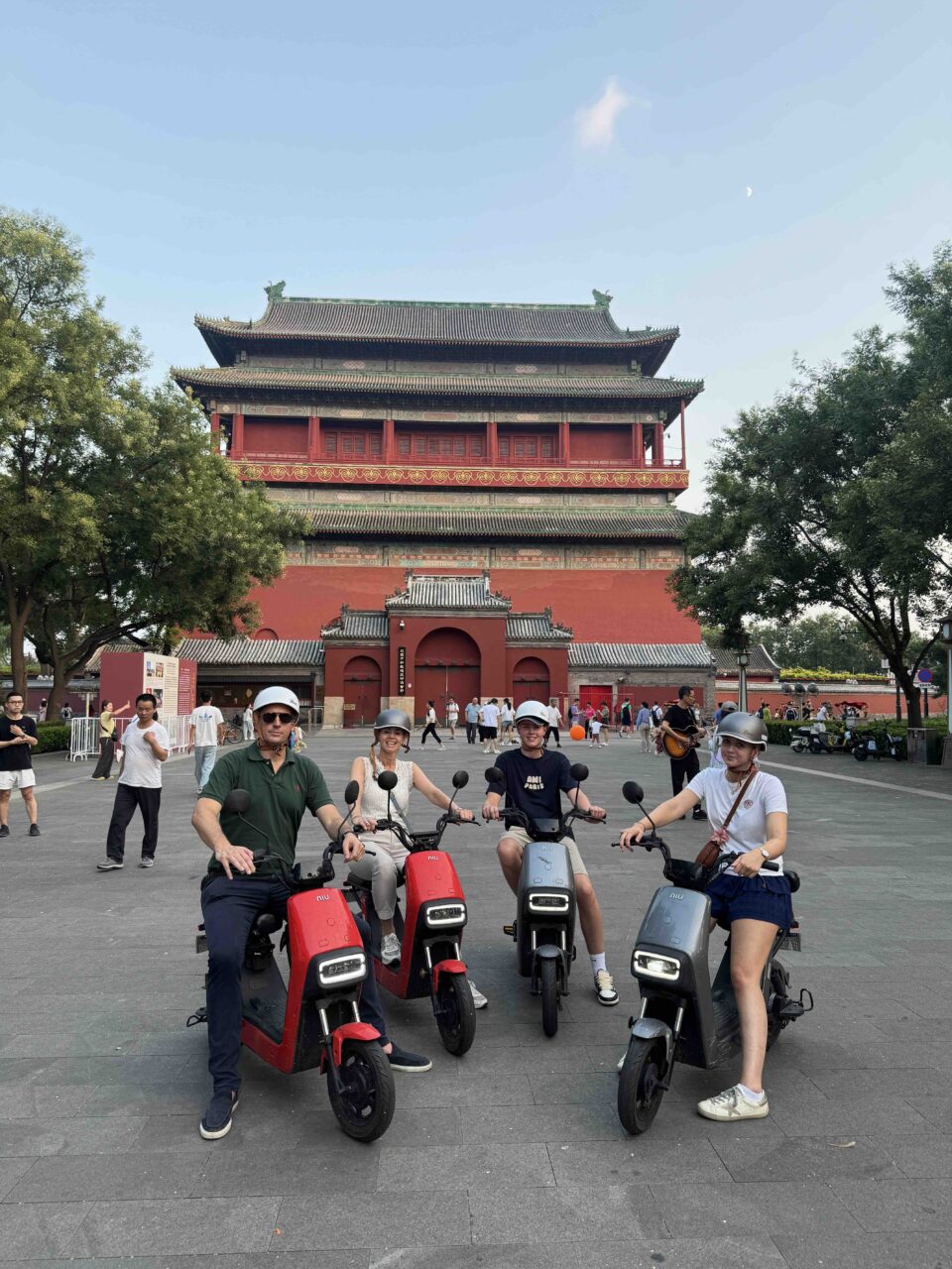 A traveling family biking through historic hutongs, smiling — redefining local time in Beijing with every step.