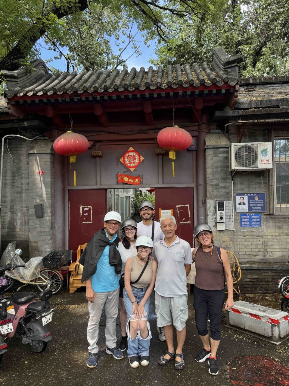 A local host warmly greeting international guests at his hutong home — authentic hospitality during local time in Beijing.