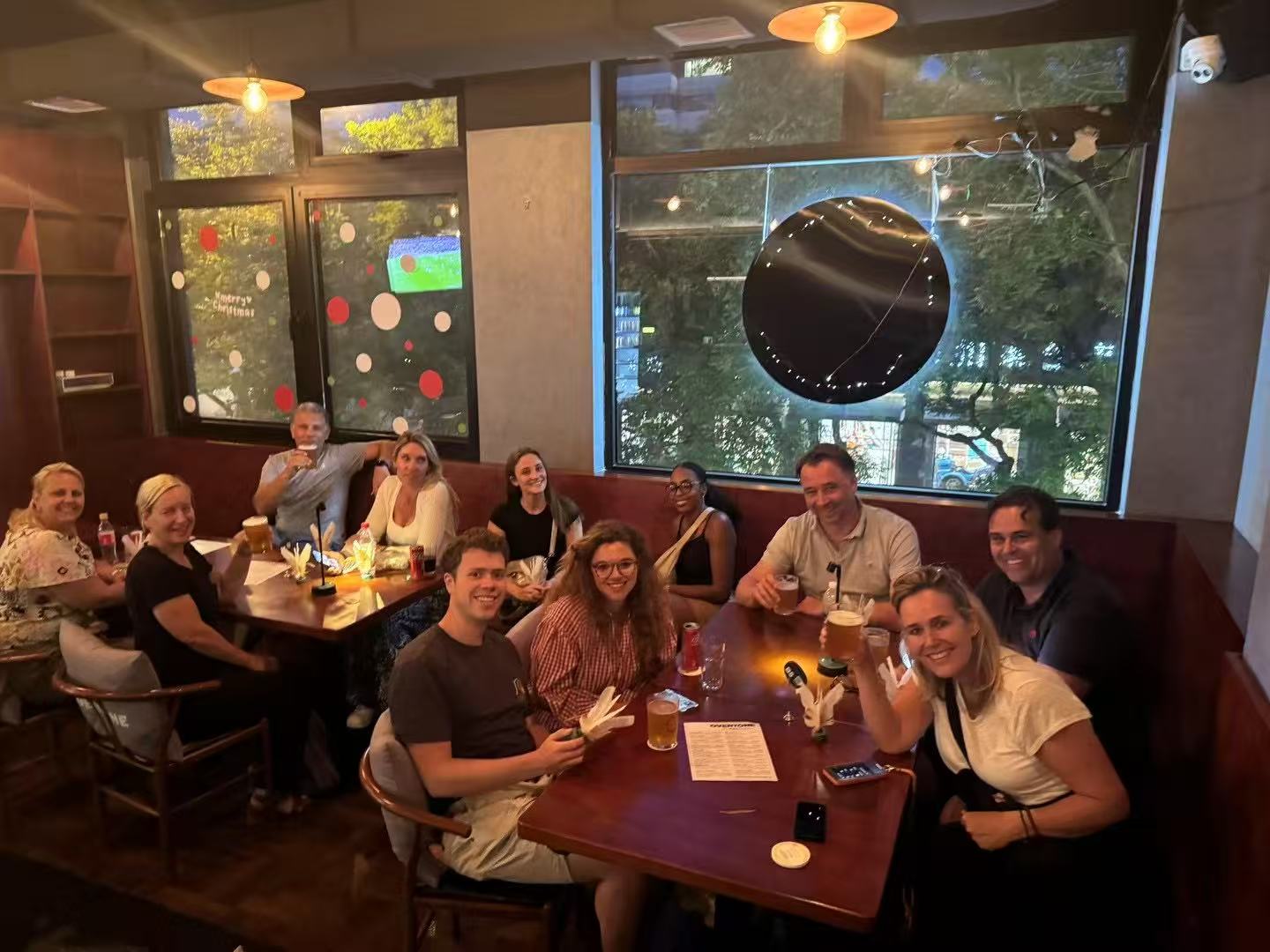 Friends enjoying craft beer in a cozy hutong bar on a rainy day in Beijing
