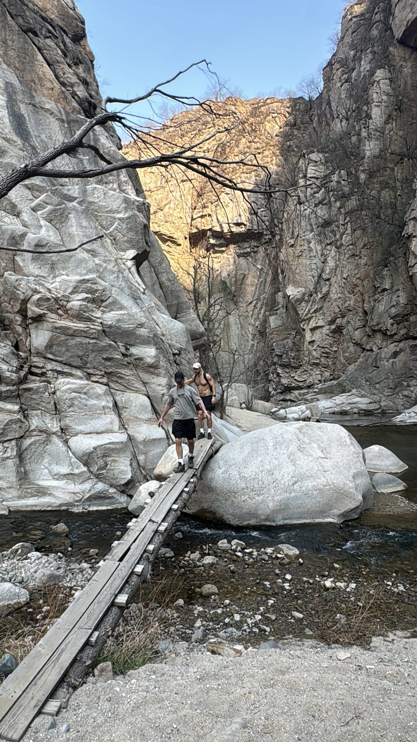 Hikers following a clear mountain river through a rocky Miyun canyon near Beijing